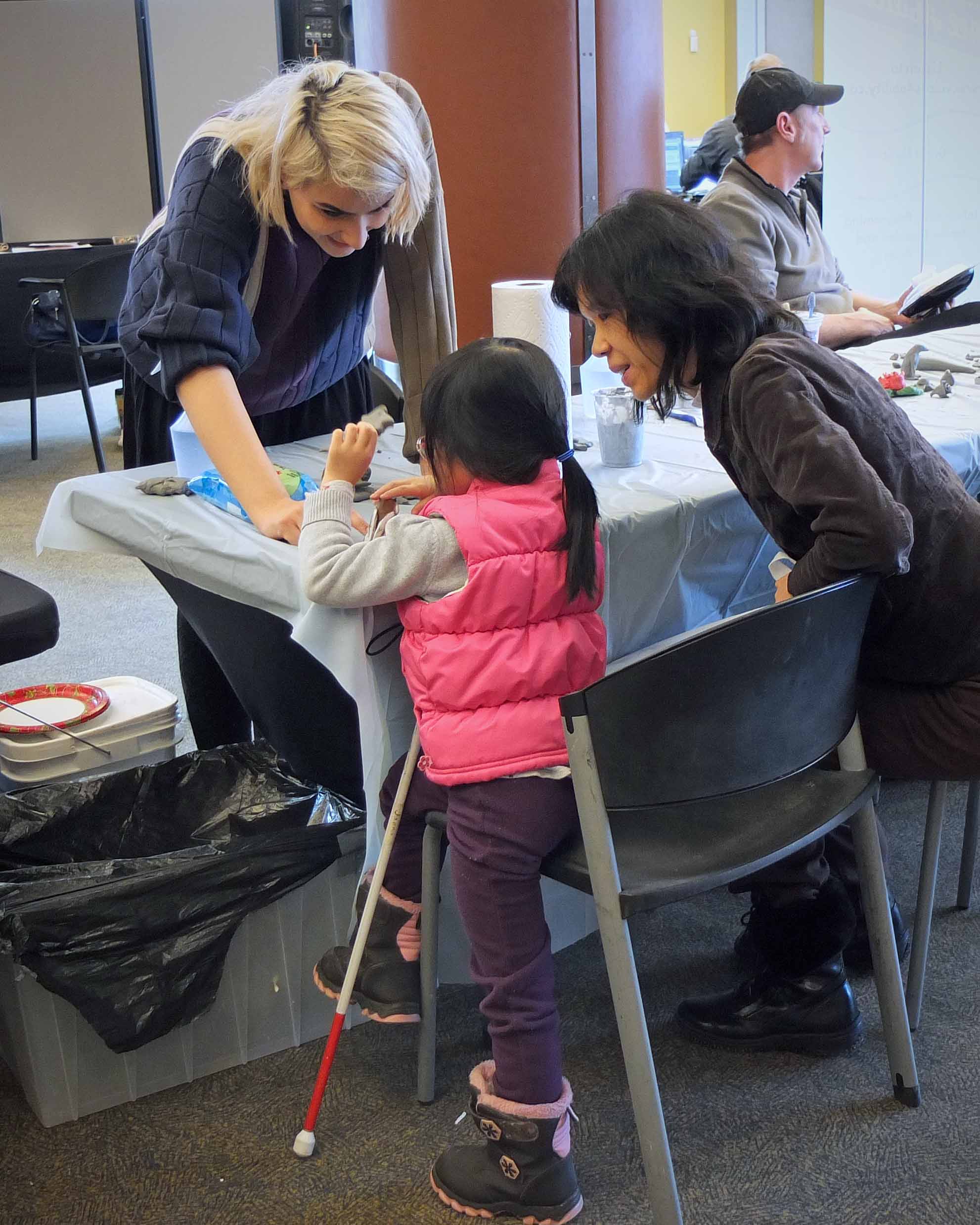 A little girl tries sculpting in clay at the Experience Expo