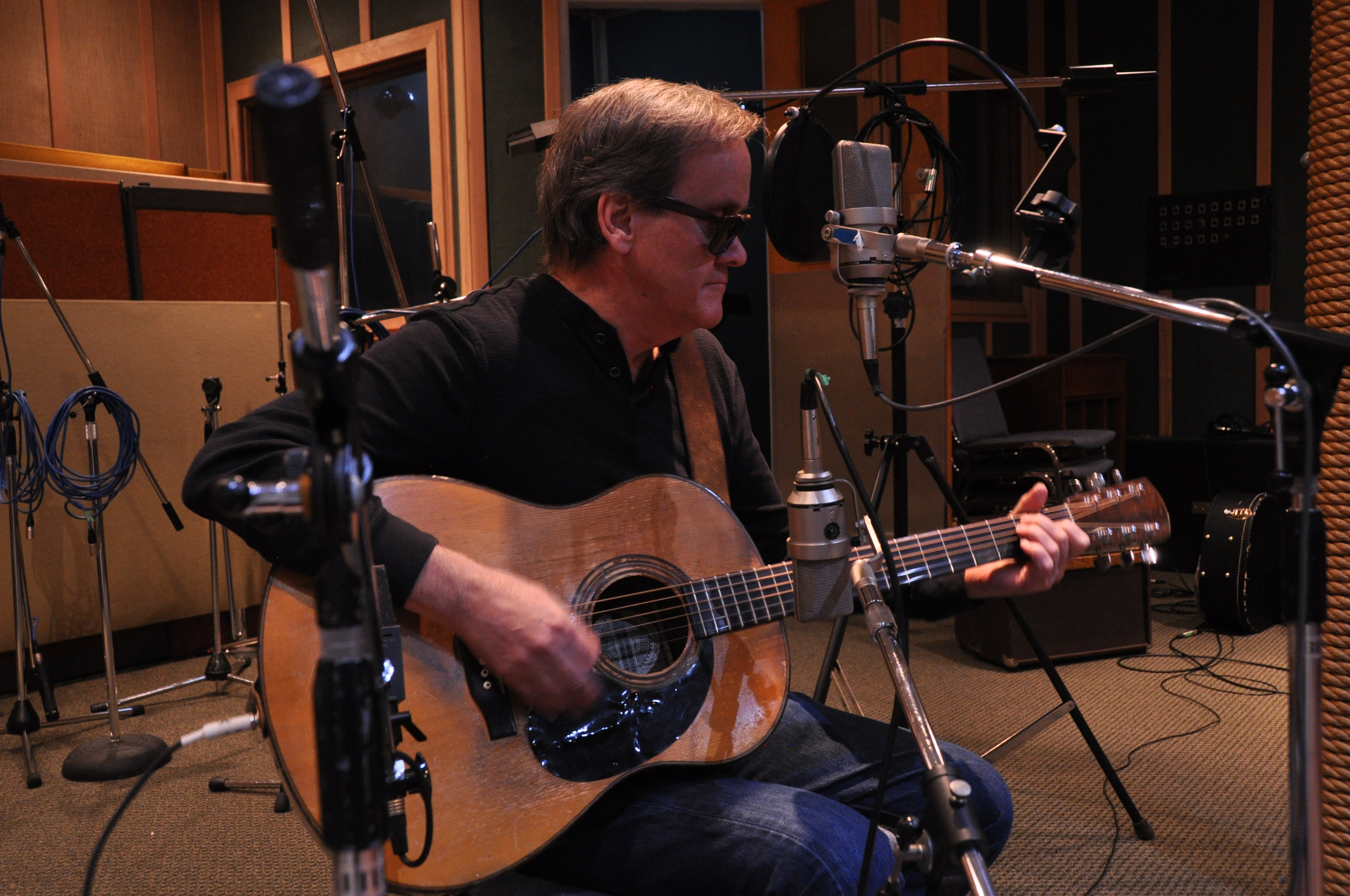 Roy Forbes playing guitar in a recording studio
